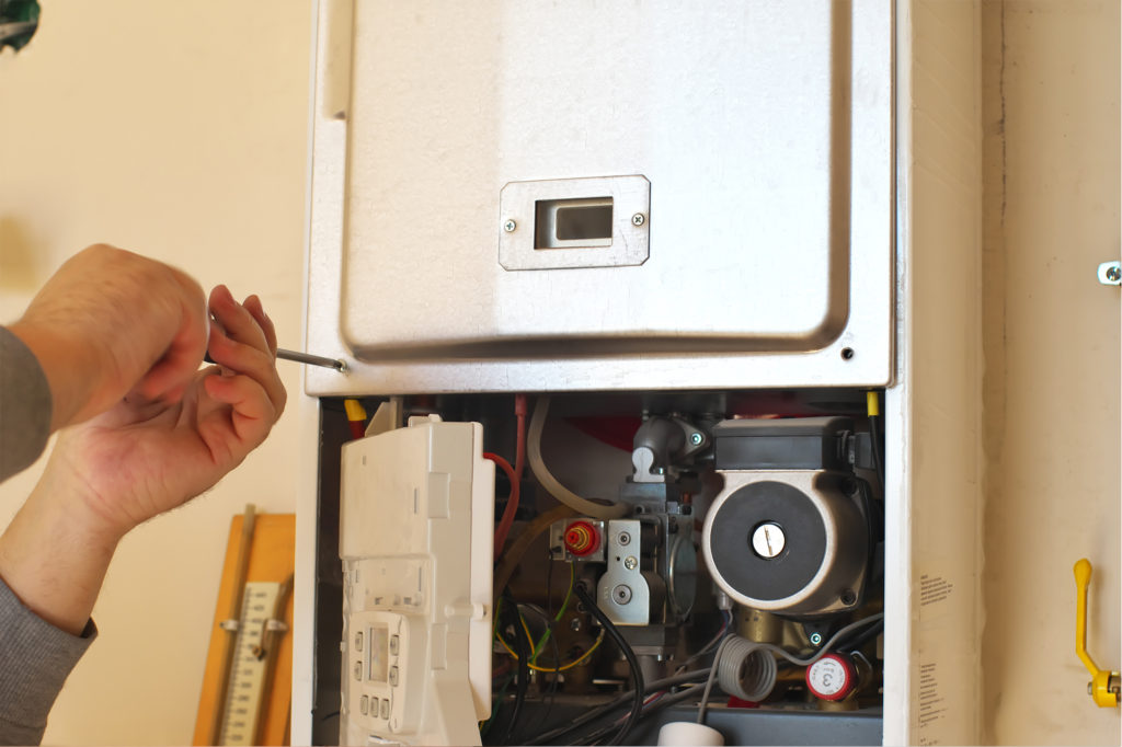 an gas engineer using a screwdriver whilst working on combi boilers