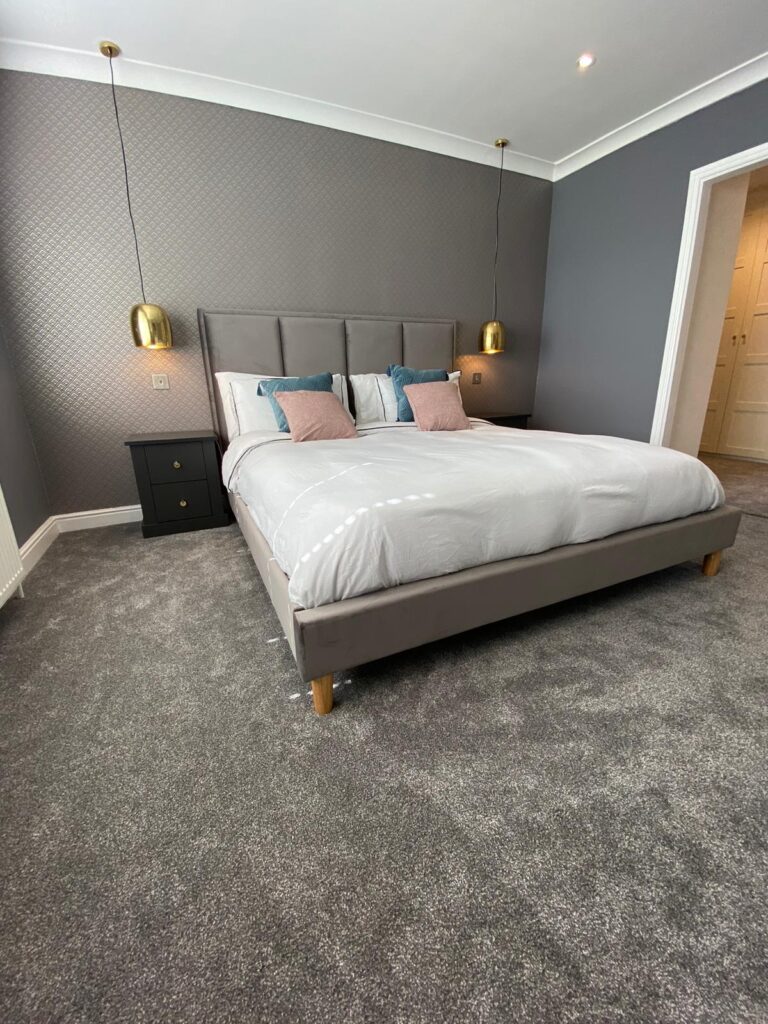 kitchen to bedroom conversion bedroom with grey carpet and gold ceiling mounted bedside lights