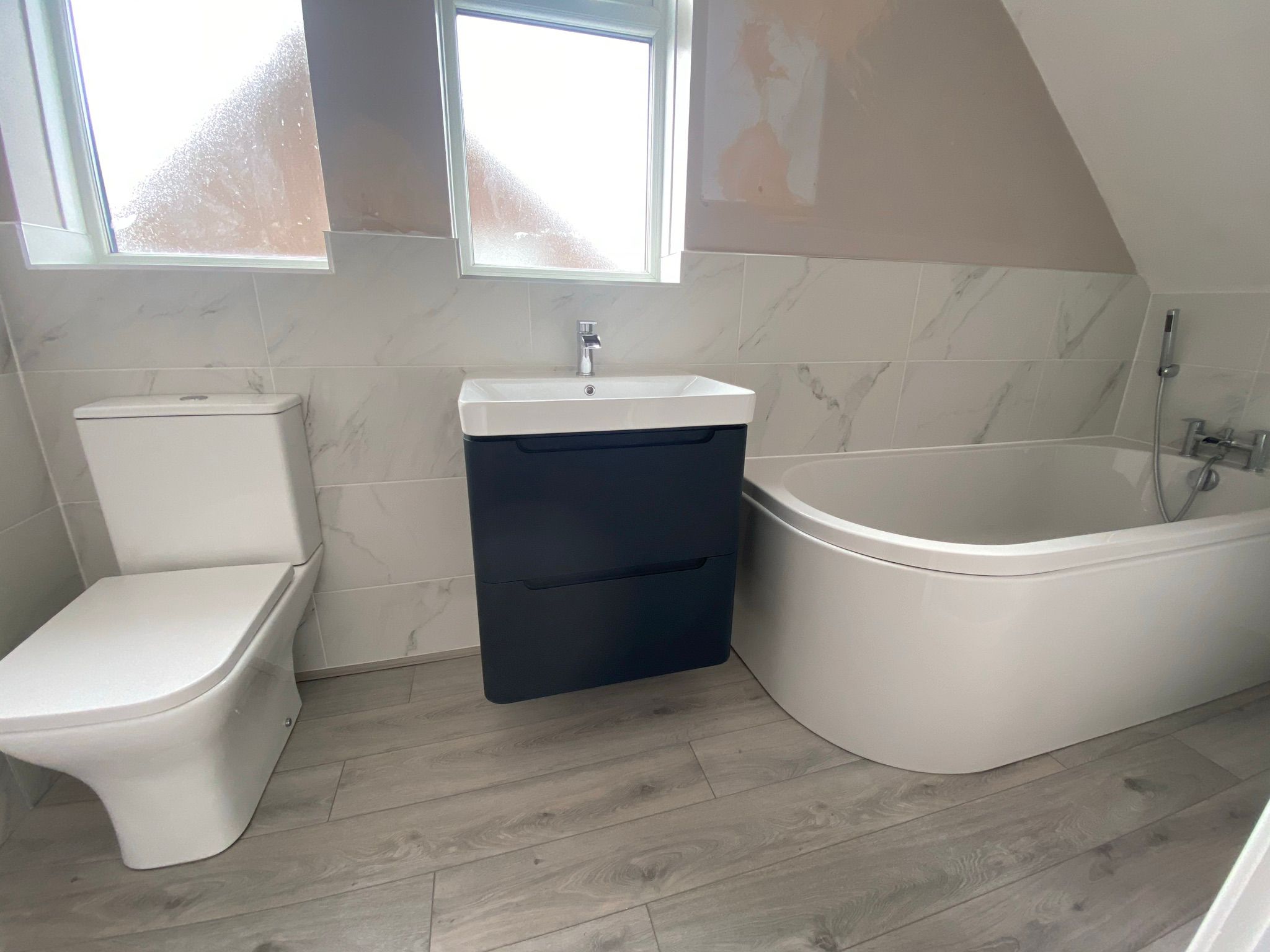 Bathroom refresh floating sink and cupbouard unit in black and white fixed to wall under window.