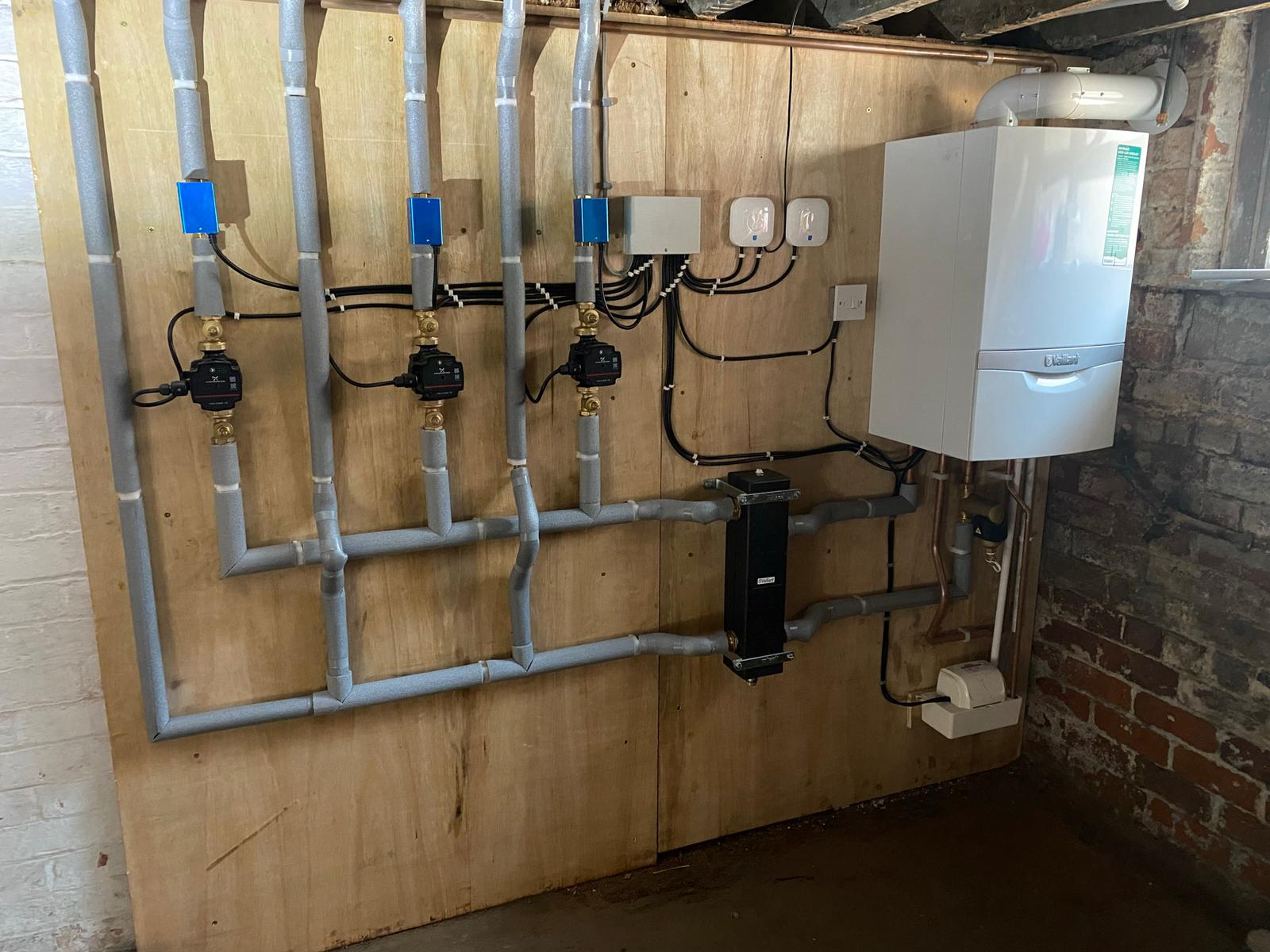 Large heating system completed showing all pipework from boiler in basement into low loss header and out to 3 circuits for heating and hot water