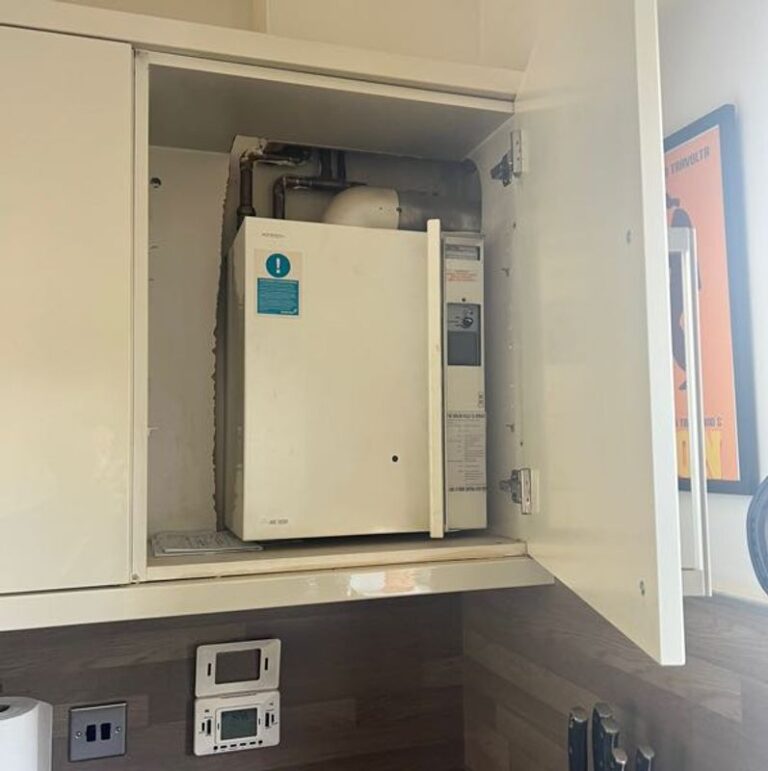 boiler in a cupboard project showing existin Potterton Suprima boiler in a kitchen cupboard with old timeswitch underneath.
