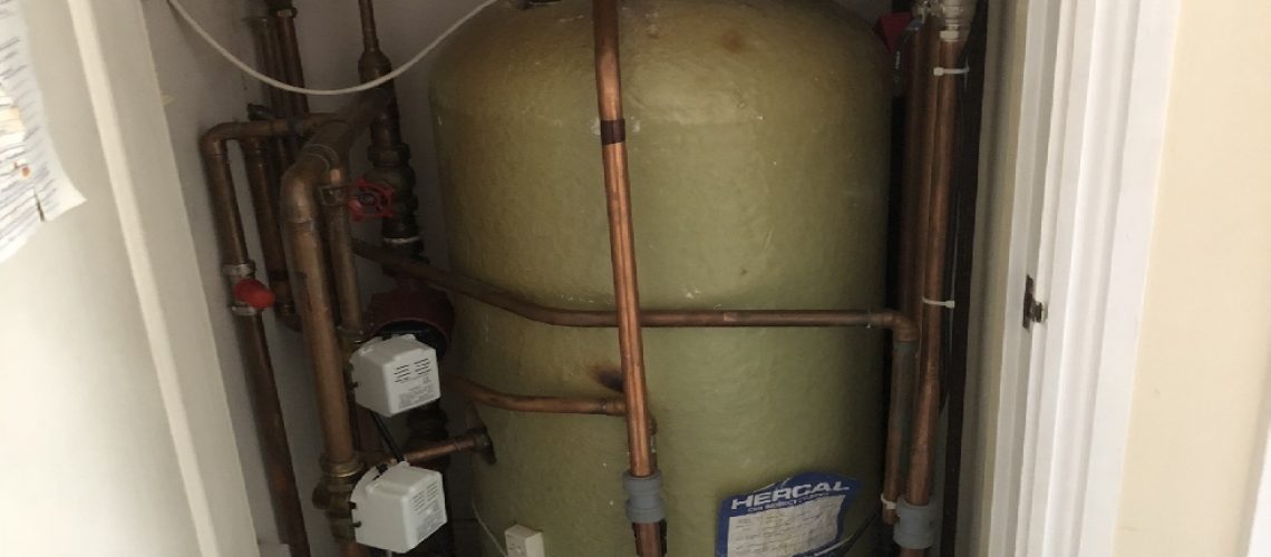 an old stored hot water cylinder in an airing cupboard