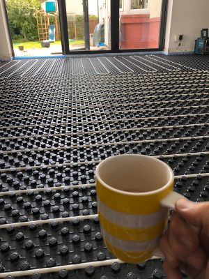 scale image of nu-heat underfloor heating pipework along side a cup of tea