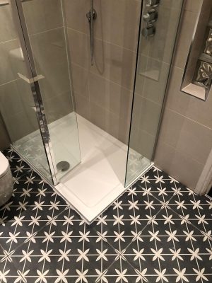 Bathroom renovation new walk in shower cubicle set into floor alonside black and white tiles