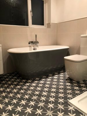 Bathroom renovation free standing bath and toilet on black and white tiles with underfloor heating.