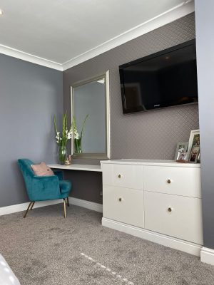 kitchen to bedroom conversion bedroom dressing table and luxury blue chair with large wall mirror and wall mounted t.v.