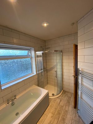 new bath, curved shower cubicle and white tessellating tiles