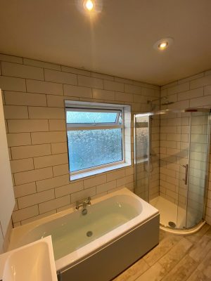new bath, curved shower cubicle and white tessellating tiles