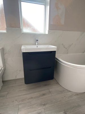 Bathroom refresh floating sink and cupbouard unit in black and white fixed to wall under window.