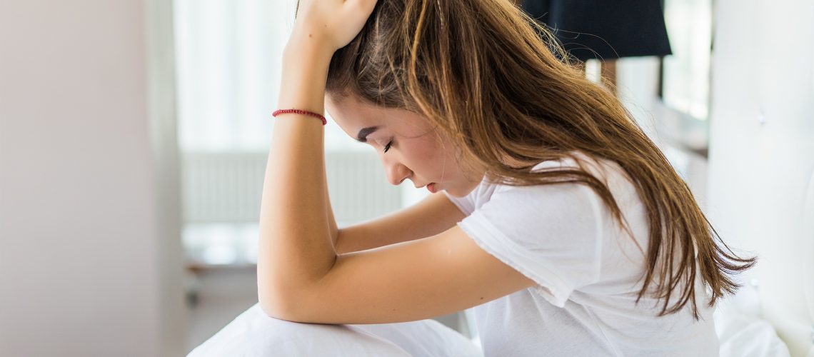 a woman in bed looking frustrated as she isn't getting the bedroom heating right