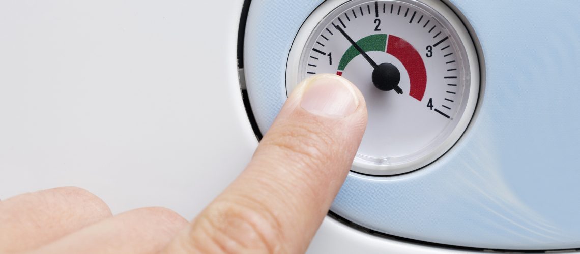 a finger points to a gauge which tells you when you need to re-pressurise your central heating system