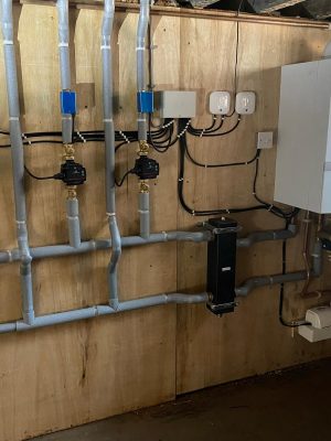 Large heating system completed showing all pipework from boiler in basement into low loss header and out to 3 circuits for heating and hot water