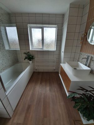 Straight swap bathroom completed bathroom showing bath and sink vanity unit with mirror and large window.