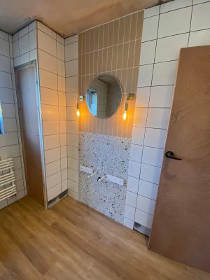 Straight swap bathroom vanity unit wall tiling complete with 2 types of tiles and mirror with wall mounted pendant lighting.