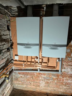 convert offices into a house project shows two 618 Vaillant system boilers fitted to a plywood covered cellar wall.