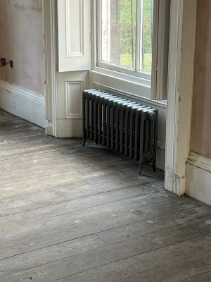 convert offices into a house project shows period original radiator under window of ground floor of property