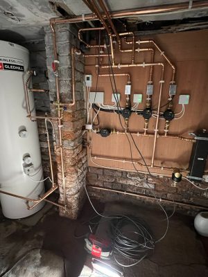 convert offices into a house project shows 300 litre unvented Gledhill cylinder and expansion vessel connected to control wall with 3 heating circuits and one hot water circuit fed by a low loss header