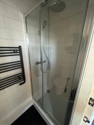 Create an ensuite sliding door shower cubicle with mixer shower.