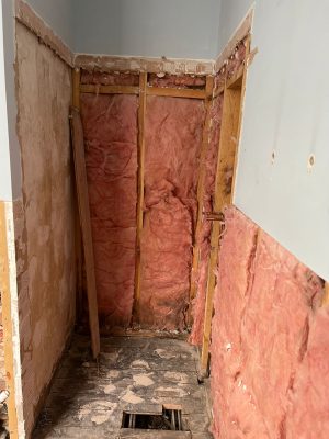 uneven bathroom floor shower alcove showing insulation in walls before tile installation