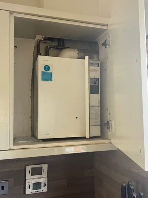 boiler in a cupboard project showing existin Potterton Suprima boiler in a kitchen cupboard with old timeswitch underneath.